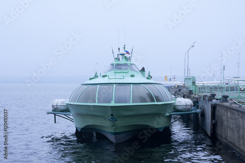 Passenger hydrofoil boat on the docks of Onego lake in foggy weather, Petrozavodsk, Karelia, Russia.