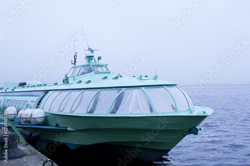 Passenger hydrofoil boat on the docks of Onego lake in foggy weather, Petrozavodsk, Karelia, Russia. © Elena Noeva