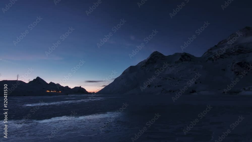 sun rising over a mountain glacier lake timelapse transition from night to day at lago bianco white lake bernina pass switzerland swiss backlit sun rays uhd 4k