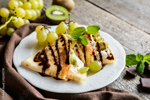 Pancakes with mascarpone filling, kiwi, grape and chocolate topping