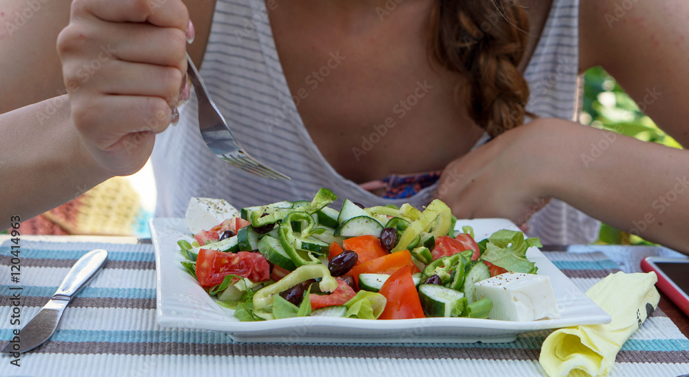 Woman eating greek salad