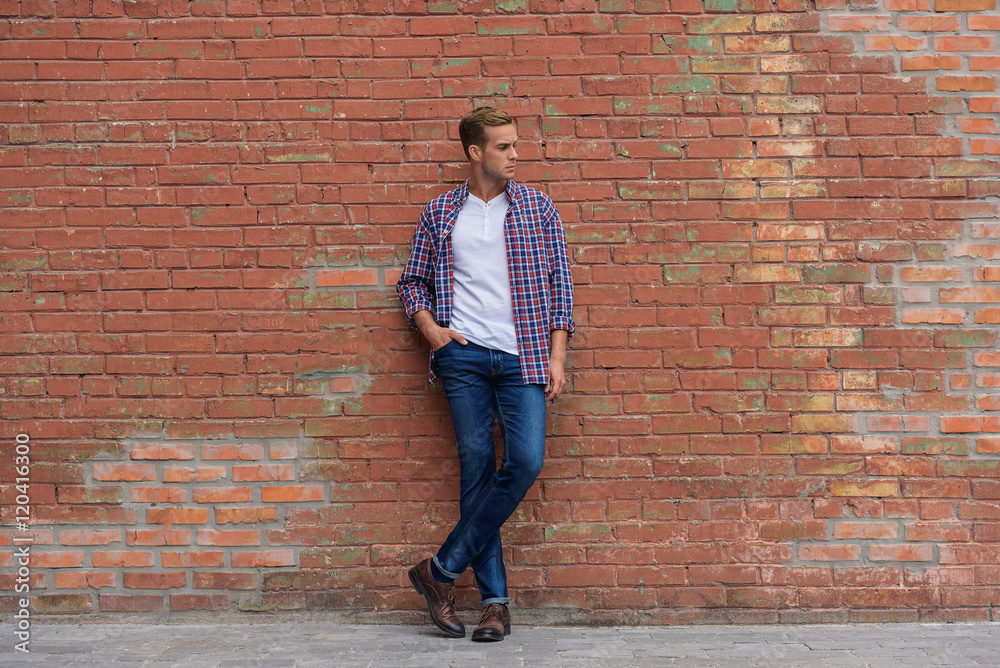 Handsome guy standing near brick wall Handsome guy standing near brick wall