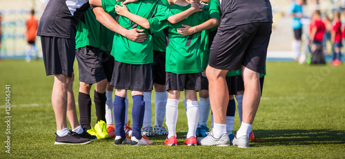 Football soccer match for children. Coach giving young soccer team instructions. Youth soccer team together. Football match for children. Team shout. Coach briefing. Football background.