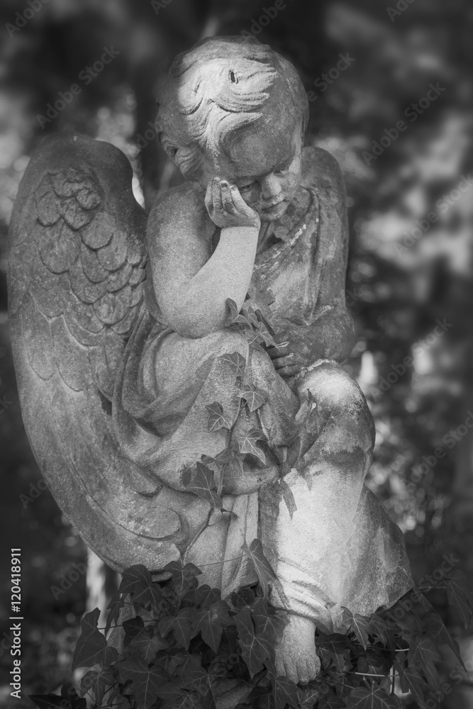 Vintage image of a sad angel on a cemetery against the backgroun