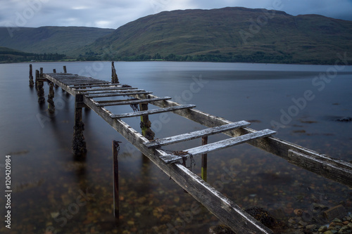 Broken wooden pier leads in a lake. 