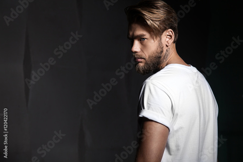 Portrait of a handsome man in a white t-shirt from the back