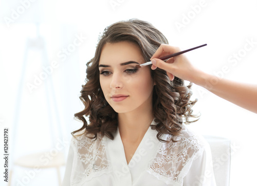 Makeup artist preparing bri...