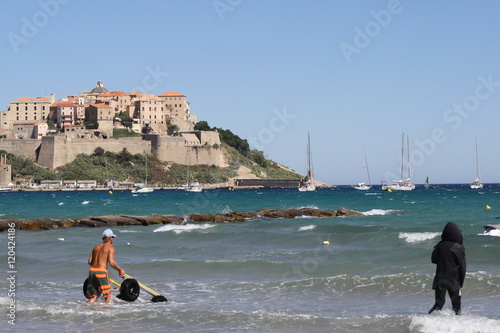 Corsica, Calvi.  A view of old city and spot man in the sea photo