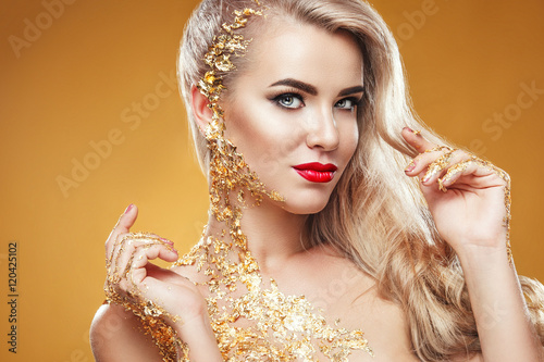 Pretty woman with golden skin and beautiful gold jewelry photo