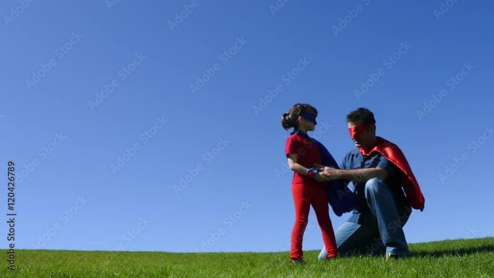 Superhero father show his daughter how to be a superhero against blue sky background with copy space. concept photo of Super hero, childhood, imagination, fatherhood and parenthood. Real people Superhero father show his daughter how to be a superhero against blue sky background with copy space. concept photo of Super hero, childhood, imagination, fatherhood and parenthood. Real people