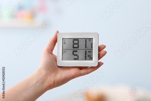 Woman checking temperature and humidity in baby room