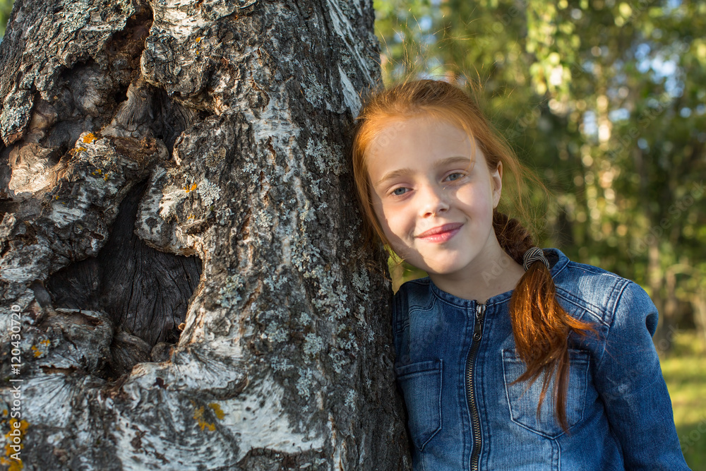 Little girl portrait near tree birch.