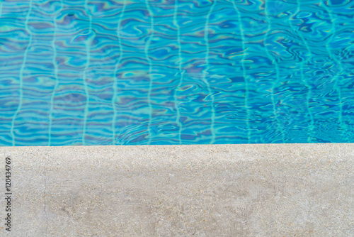 Blue swimming pool rippled water .