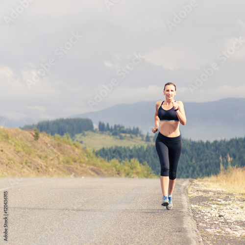 Young female runner on road cross in mountains © skumer