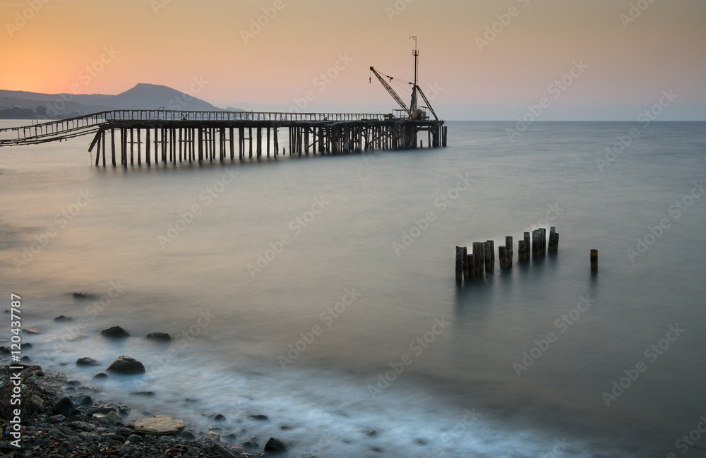 Seascape with deserted jetty during sunset
