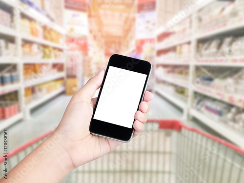 Female hand holding mobile smart phone on Supermarket blur backg