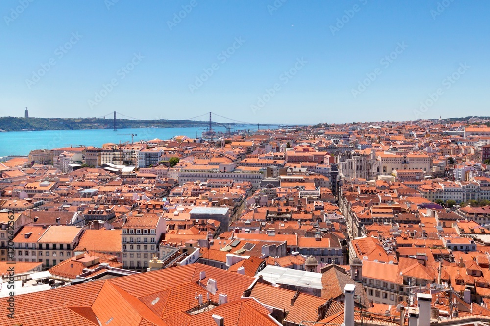 Lisbon red roofs, river with bridge cityscape on sunny day