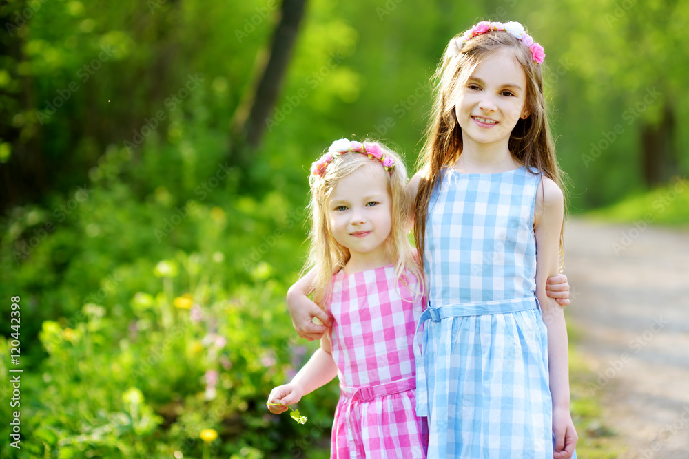 Two adorable little sisters laughing and hugging each other Two adorable little sisters laughing and hugging each other