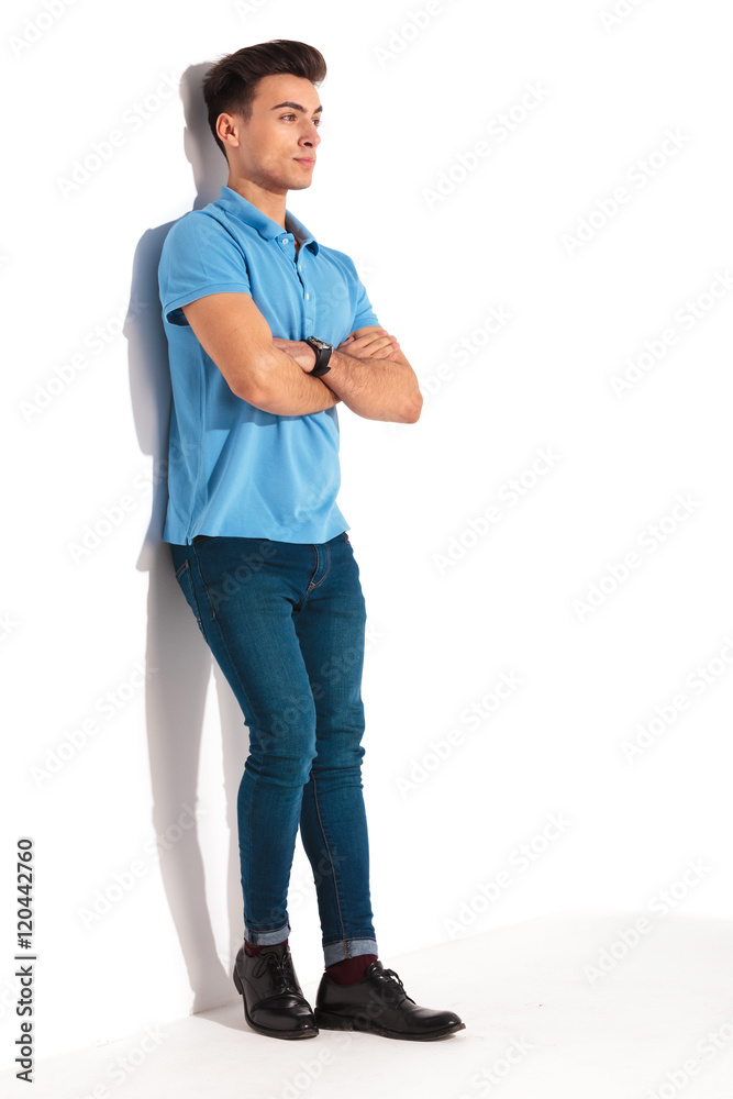 Fototapeta premium man leaning against studio wall with hands crossed