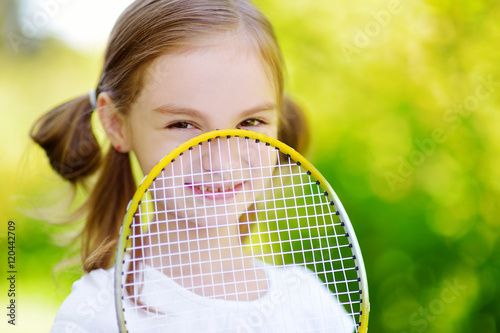 Cute little girl playing badminton outdoors