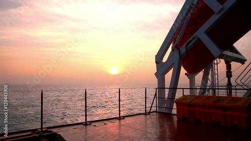 Cargo ship underway at sunset photo