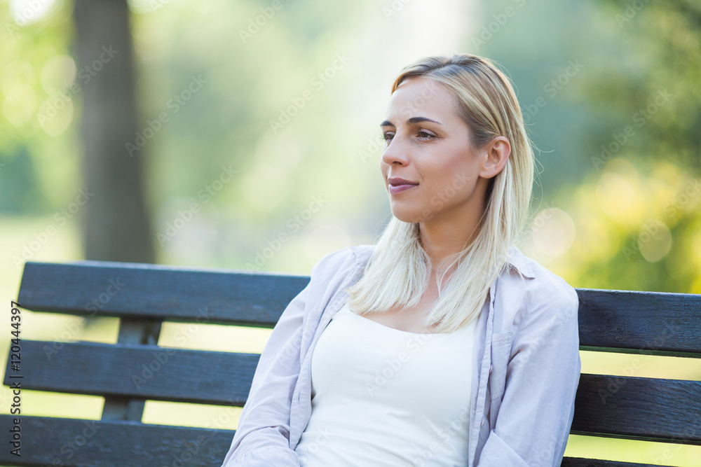 Young happy woman is sitting and relaxing in park. Young happy woman is sitting and relaxing in park.