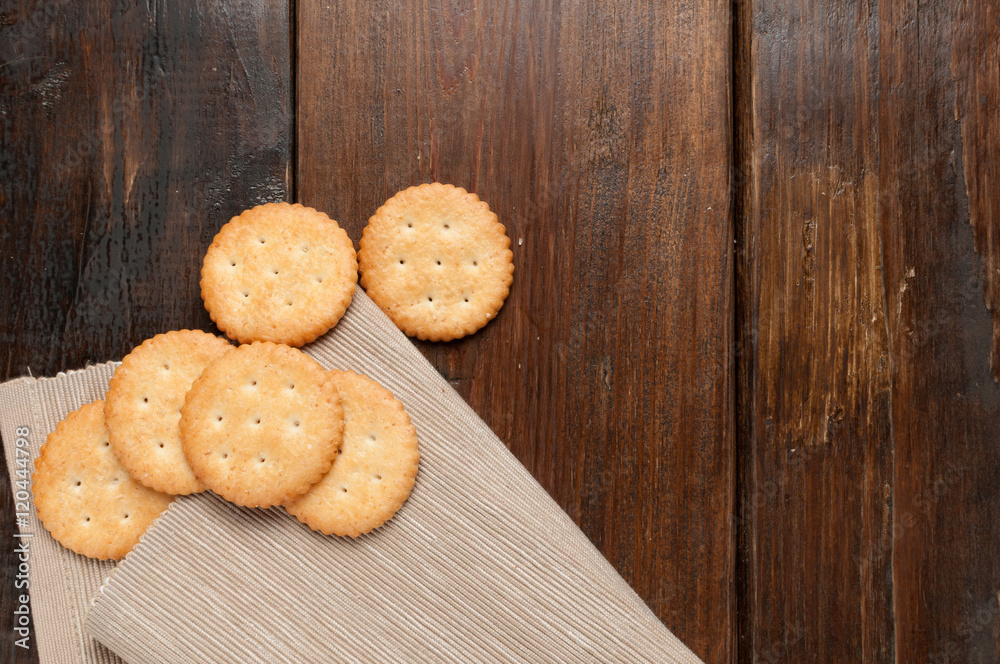cracker stacked on brown fabric over wood table cracker stacked on brown fabric over wood table