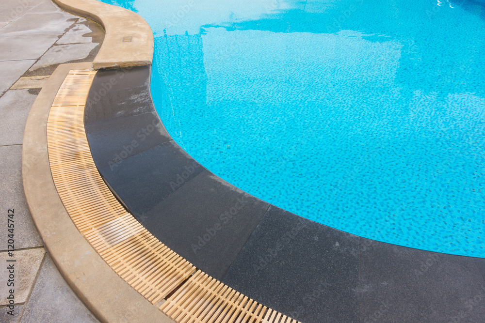 Blue swimming pool rippled water .