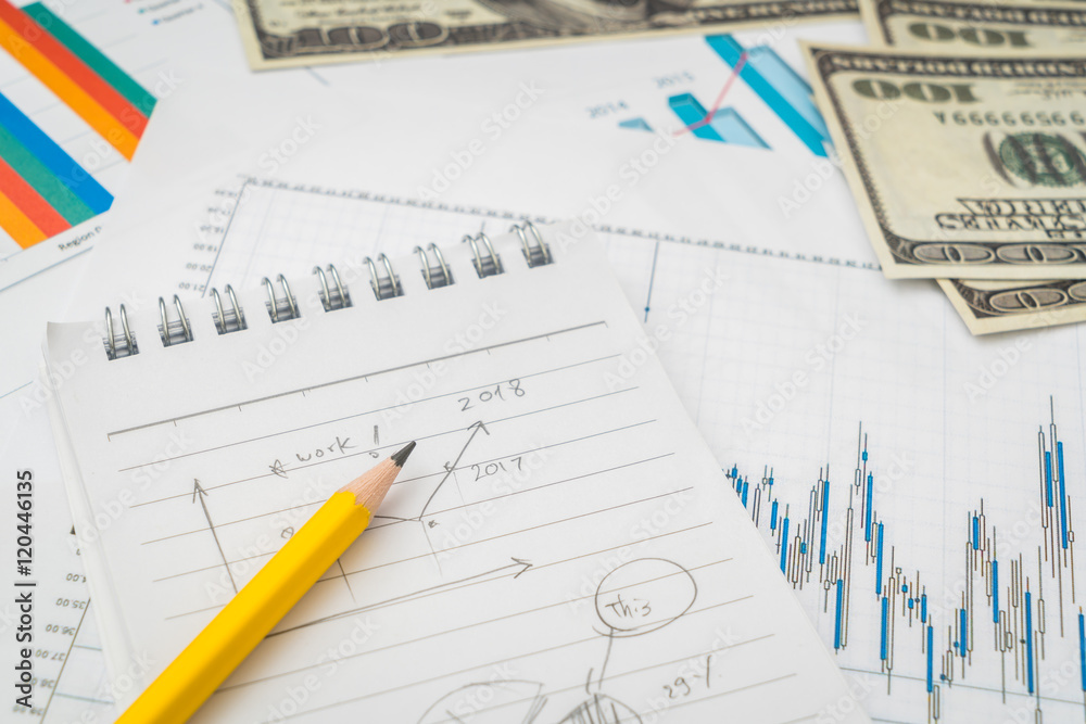 Financial charts on the table with dollars banknotes . Financial charts on the table with dollars banknotes .