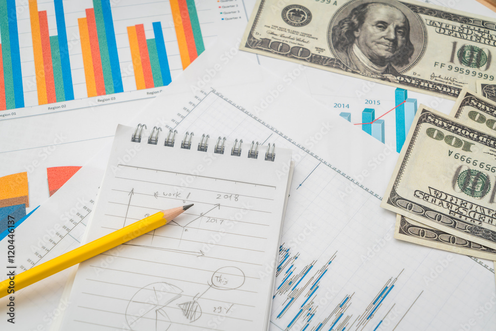 Financial charts on the table with dollars banknotes . Financial charts on the table with dollars banknotes .