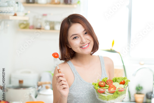 Dieting concept. Healthy Food. Beautiful Young Asian Woman eatin photo