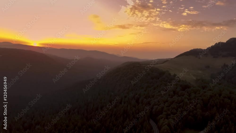 aerial view of road through mountain forest at sunset
aerial view of road through mountain forest at sunset