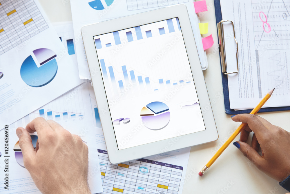 Business, analysis and strategy. Close-up of touch pad with charts and diagrams on screen. Businesspeople using tablet for discussing financial data, planning, developing new vision for their company Business, analysis and strategy. Close-up of touch pad with charts and diagrams on screen. Businesspeople using tablet for discussing financial data, planning, developing new vision for their company