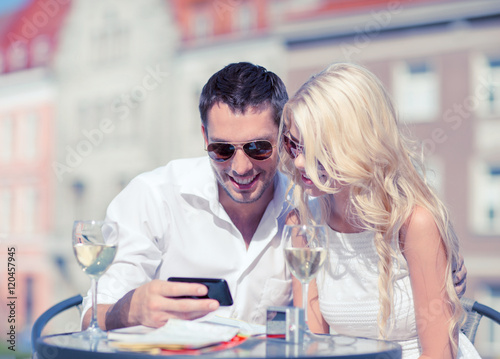 couple looking at smartphone in cafe