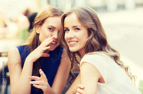 young women drinking coffee and talking at cafe