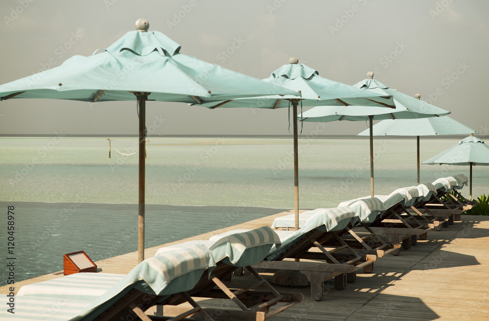 Fototapeta premium parasol and sunbeds by sea on maldives beach