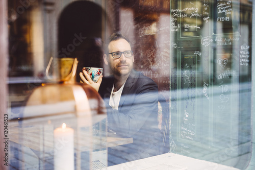 Sweden, Stockholm, Gamla Stan, Man relaxing in cafe seen through window
