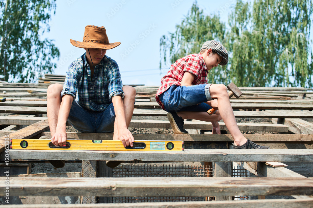 Two brothers in the process of construction of the roof of a barn in the village Two brothers in the process of construction of the roof of a barn in the village