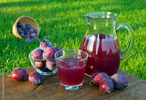 prune juice in the carafe and glass with plums