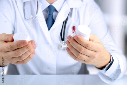Doctor in a white labcoat choosing medicament between two drug