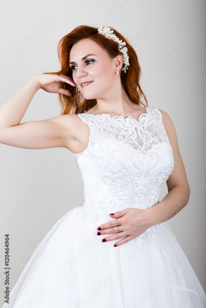 red-haired bride in a wedding dress holding wedding bouquet, bright unusual appearance. Beautiful wedding hairstyle and bright make-up red-haired bride in a wedding dress holding wedding bouquet, bright unusual appearance. Beautiful wedding hairstyle and bright make-up