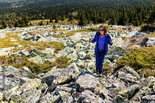 Female is trekking in Mountains among field of stones and rocks. © EdNurg