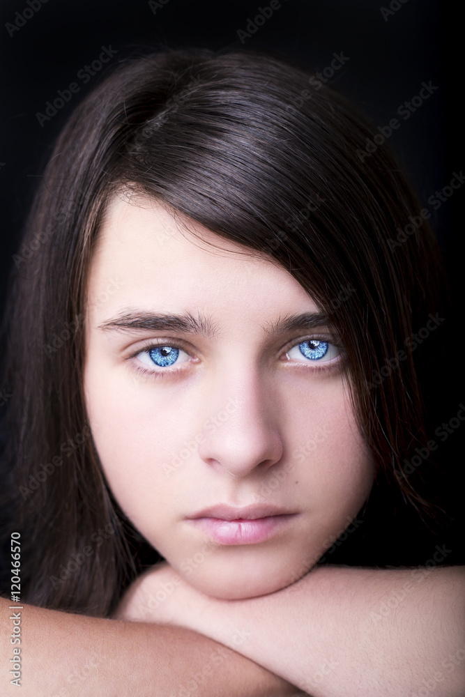 A portrait of a handsome blue eyes teenager on dark background A portrait of a handsome blue eyes teenager on dark background
