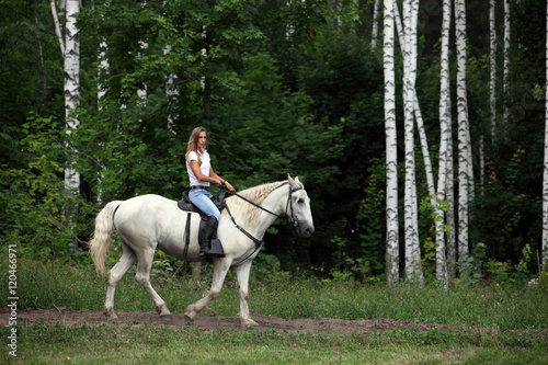 Girl galloping horse on a background of green wood © horsemen