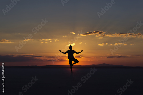 Yoga posture on sunset by man