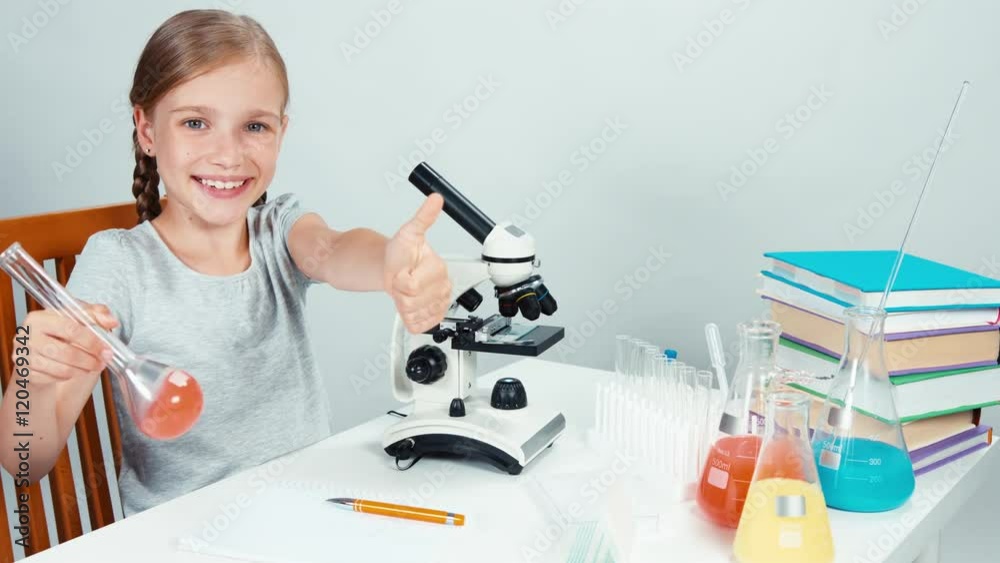 Portrait schoolgirl child 7-8 years holds flask and smiling at camera Portrait schoolgirl child 7-8 years holds flask and smiling at camera