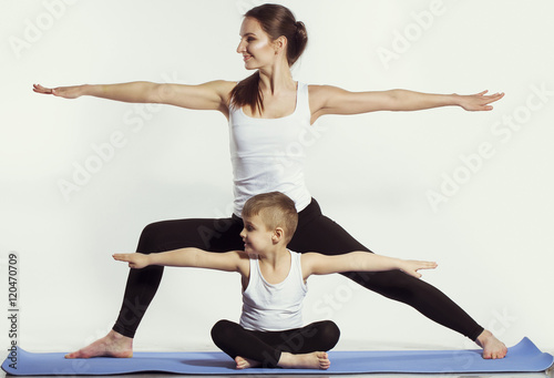 mother and son doing yoga (sports exercises), have fun and spend a good time together . isolated on white. the concept of a healthy lifestyle