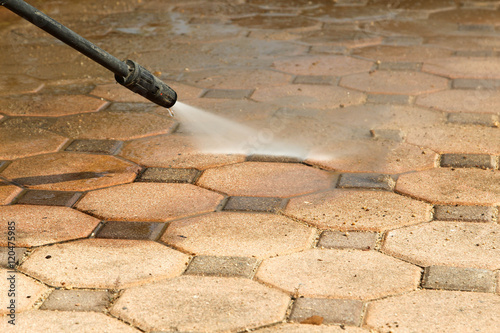 Cleaning concrete block floor by high pressure water jet.
