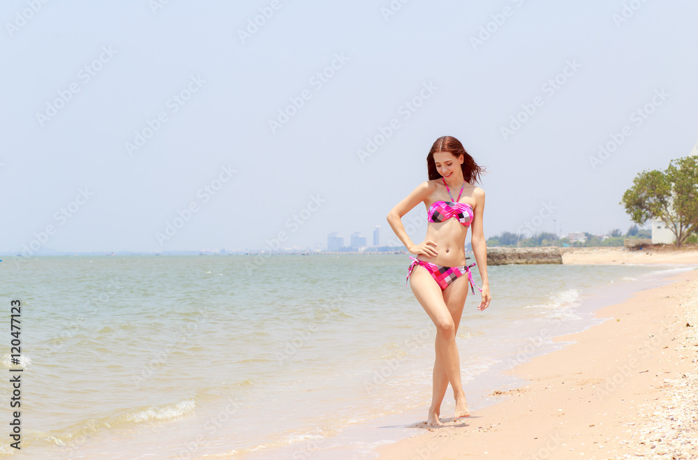 Beautiful women in bikinis strolling happily along the beach. Beautiful women in bikinis strolling happily along the beach.