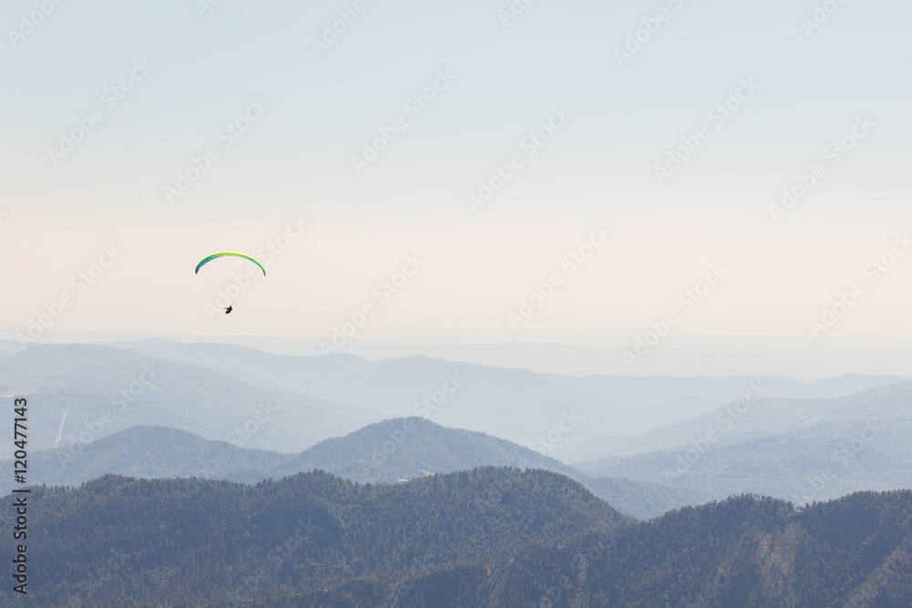 Paraglider flying over mountains Paraglider flying over mountains
